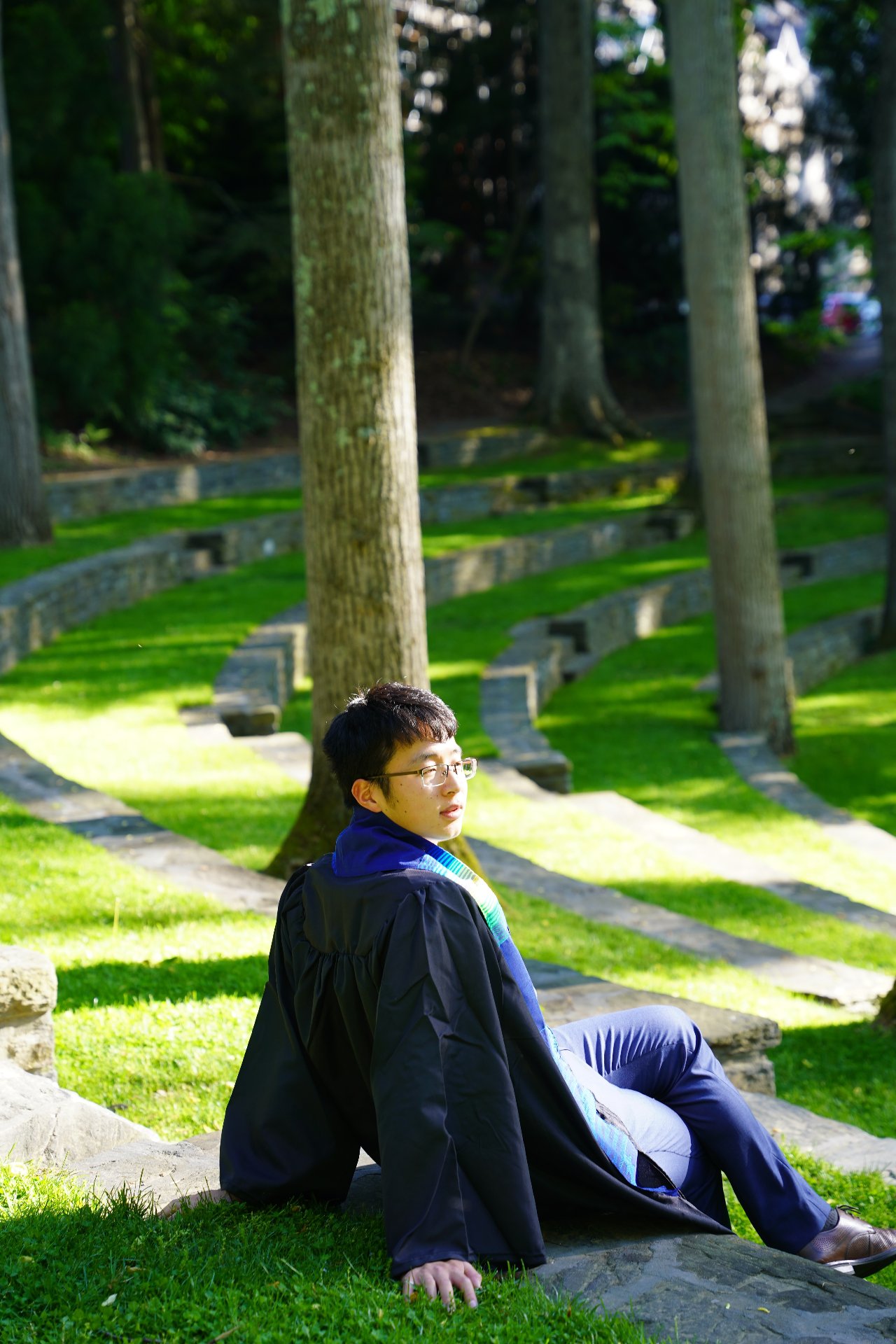 Howard Wang in graduation gown on campus steps